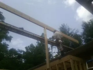 Carpenter setting a ridge beam over a new addition frame — Ice Dam Removal by Roofing Brothers in Granby